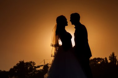 Sunset arka planında genç bir gelin ve damadın silueti