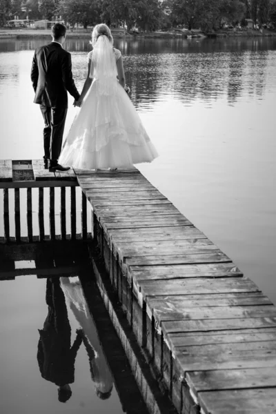 Noiva feliz e noivo em seu dia de casamento um lago preto e whi — Fotografia de Stock