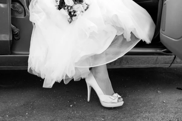 Shoe of the bride, bride with leg outside of car, black and whit