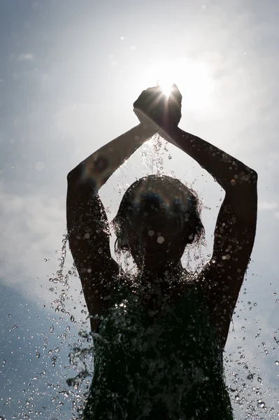 Spruzzare acqua sul waman silhouette — Foto Stock