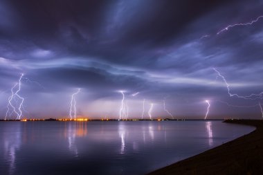 Fırtına ve Lightning'ler gece reflaction bir göl üzerinde
