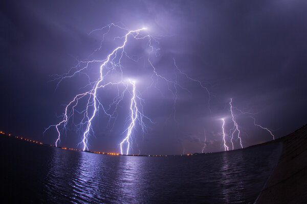 Thunderstorm and lightnings in night over a lake with reflaction