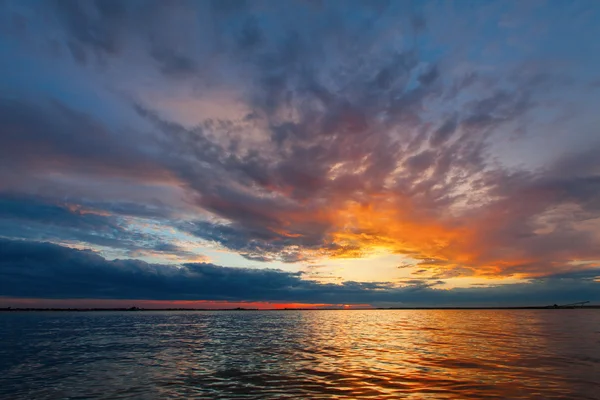 Pôr do sol sobre um lago com cores bonitas — Fotografia de Stock