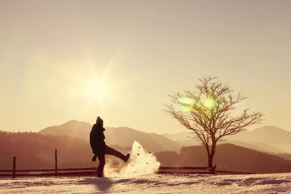 Silhueta de fotógrafo brincando com neve ao nascer do sol — Fotografia de Stock