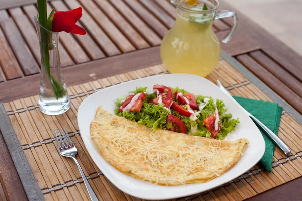 Omelete com salada vegetal em uma mesa de madeira com limonada — Fotografia de Stock