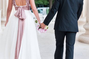 Düğün çifti el ele tutuşuyor.