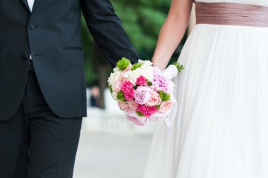 Düğün çifti el ele tutuşuyor.