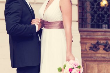 Düğün çifti el ele tutuşuyor.