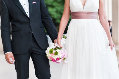 Düğün çifti el ele tutuşuyor.