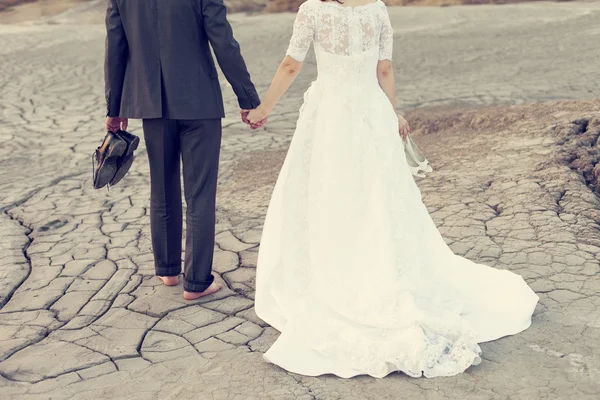Hochzeitspaar hält Kleid mit schmutzigem Kleid auf Müll — Stockfoto