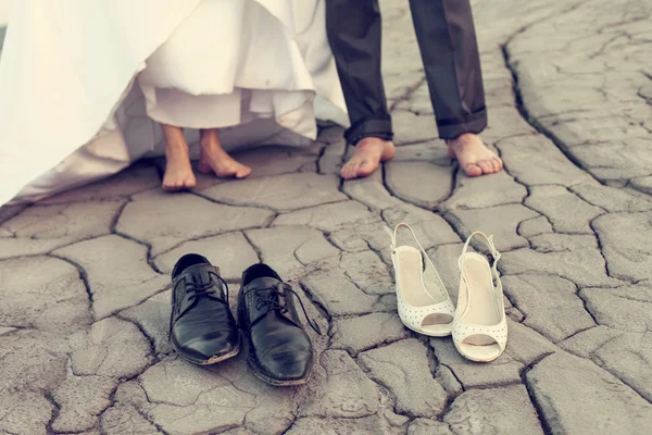 Benen van bruidspaar in vuile schoenen — Stockfoto