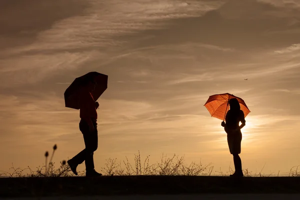 Silhouet van de zwangere vrouw en een man in de zonsondergang — Stockfoto