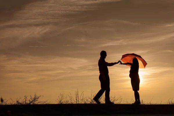 Silhouette der schwangeren Frau und ein Mann in den Sonnenuntergang — ストック写真