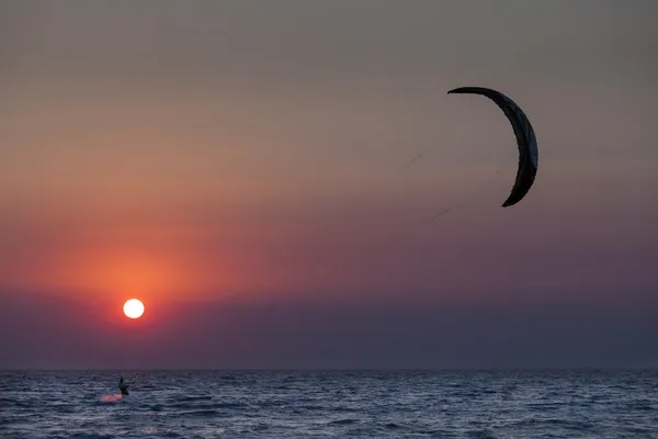 航行在日落时的 kitesurfer 的剪影 — 图库照片