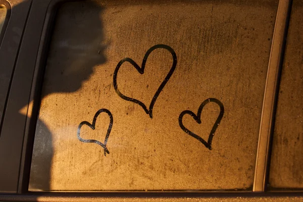 Os corações atraem a água da janela de um carro com a sombra da mulher — Fotografia de Stock