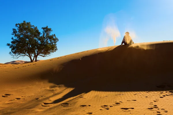 Berber playing and throwing with sands in Desert Sahara, creatin