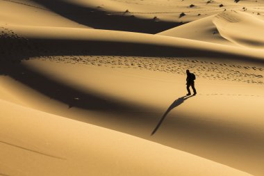 çöl dunes üzerinde yürüyen adam