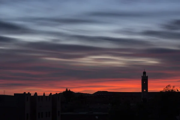 Traditional Mosque in Morocco in sunrise with moving red clouds — Stock Photo, Image