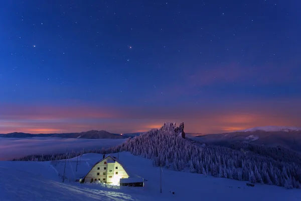 Hütte im Winter Berg in der Nacht mit Hintergrund voller Sterne — Stockfoto