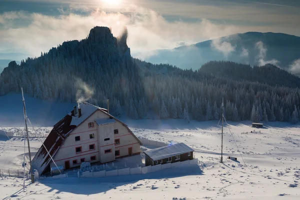 Hütte im Winter Berg bei Sonnenuntergang mit buntem Hintergrund — Stockfoto