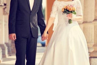 Düğün çifti el ele tutuşuyor.