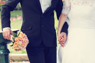 Düğün çifti el ele tutuşuyor.