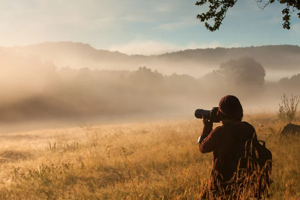 Photographer in forest with fog looking for adventure — Stock Photo, Image