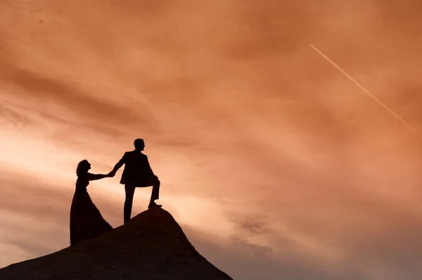 Silhouette des Hochzeitspaares mit dem roten Sonnenuntergang — Stockfoto