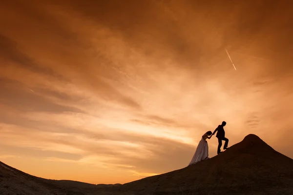Σιλουέτα του γαμήλιο ζεύγος με το κόκκινο ηλιοβασίλεμα — Φωτογραφία Αρχείου