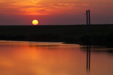 Sunrise bir göl üzerinde yansıması ile bir ağaç