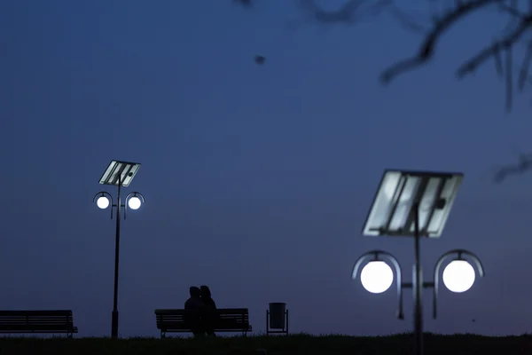 Glückliches verliebtes Paar auf Bank in der Nacht — Stockfoto