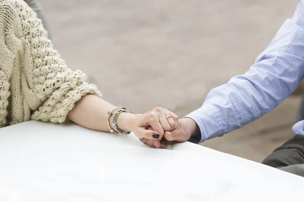 Primer plano de un hombre sosteniendo la mano de su novia en el restaurante —  Fotos de Stock