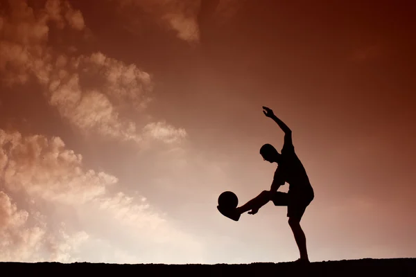 Σιλουέτα του ανθρώπου ποδόσφαιρο που παίζει με την μπάλα — Φωτογραφία Αρχείου