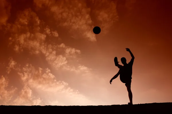 Силуэт футболиста, играющего с мячом — стоковое фото