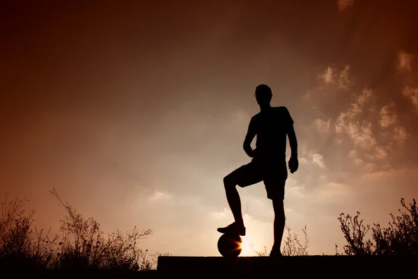 Silhouette of soccer man resting with foot on ball — Stock Photo, Image