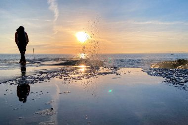 2022 _ 01 _ 08 _ İnsanlar Camogli Sahili, Cenova, İtalya, kış mevsiminde günbatımında eğleniyor