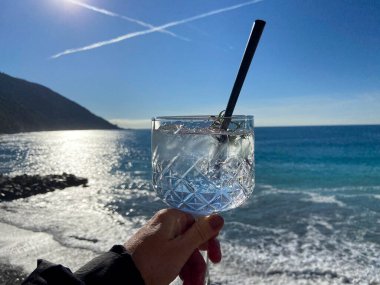 Kışın Camogli, Geonva 'da denizin önünde bir bardak cin tonik.