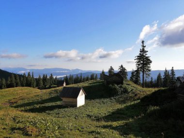 Mavi gökyüzü ve bulutların arka planında Karpatlar manzaralı dağ kulübesi 