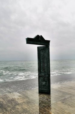 Odesa şehrinin rıhtımındaki kapı Karadeniz 'in gri dalgalarının arka planında.