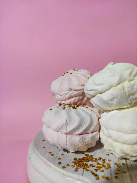 Pink and white marshmallows on a bright pink background