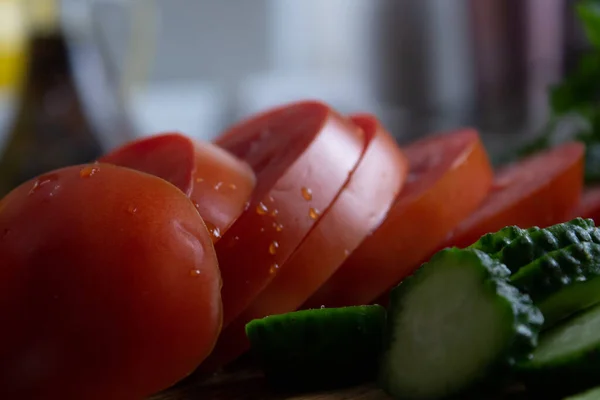Sliced tomatoes and cucumbers in the kitchen close-up