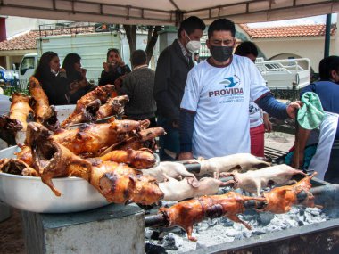 Cuenca, Ekvador - 7 Kasım 2021 Cuenca 'da yemek festivali. Satıcı ızgarada yemek pişirir ve Güney Amerika 'nın geleneksel lezzetli yemekleri olan kızarmış kobay (Latin Amerika' da cuy) satar.
