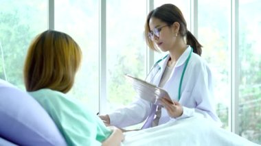 Hasta yatağında doktorla konuşuyor. Hastanenin sağlığını kontrol etmek için..