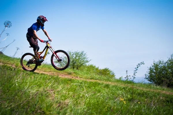 Dounhill cyclist in mountains — Stock Photo, Image