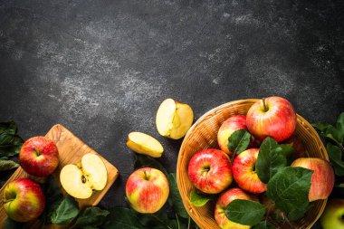 Beyaz masadaki sepetin içinde taze kırmızı elmalar.