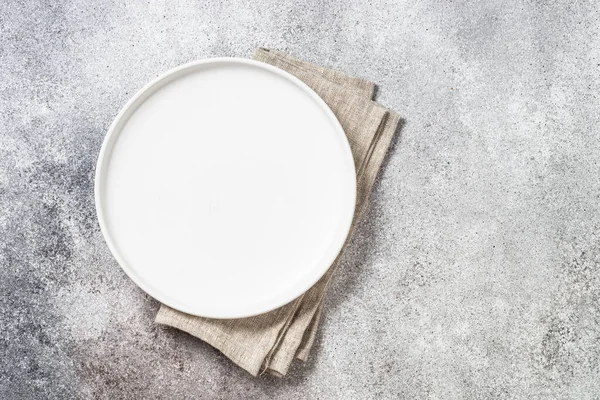Witte plaat en servet aan keukentafel. — Stockfoto