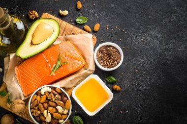 Sağlıklı yağ ürünleri siyah arkaplanda.