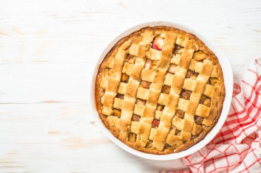 Beyaz ahşap masada zencefilli ve tarçınlı elmalı turta.