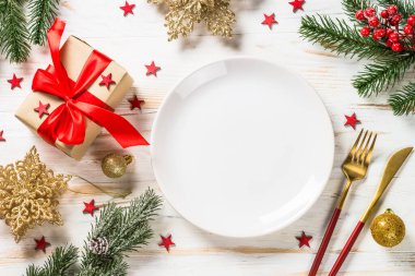 Noel süslemeleri ve beyaz ahşap masada önceden ayarlanmış kutuyla Noel masası..