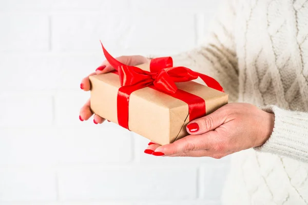 Mujer celebrar regalo de Navidad en la caja con cinta roja. — Foto de Stock